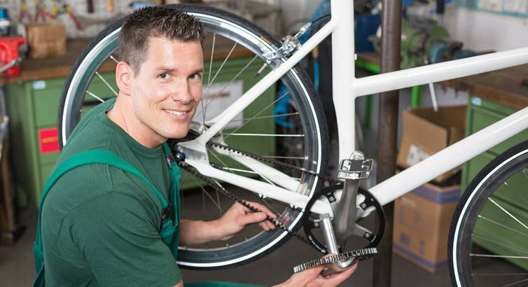 Велосипедный мастер ремонтирует велосипед